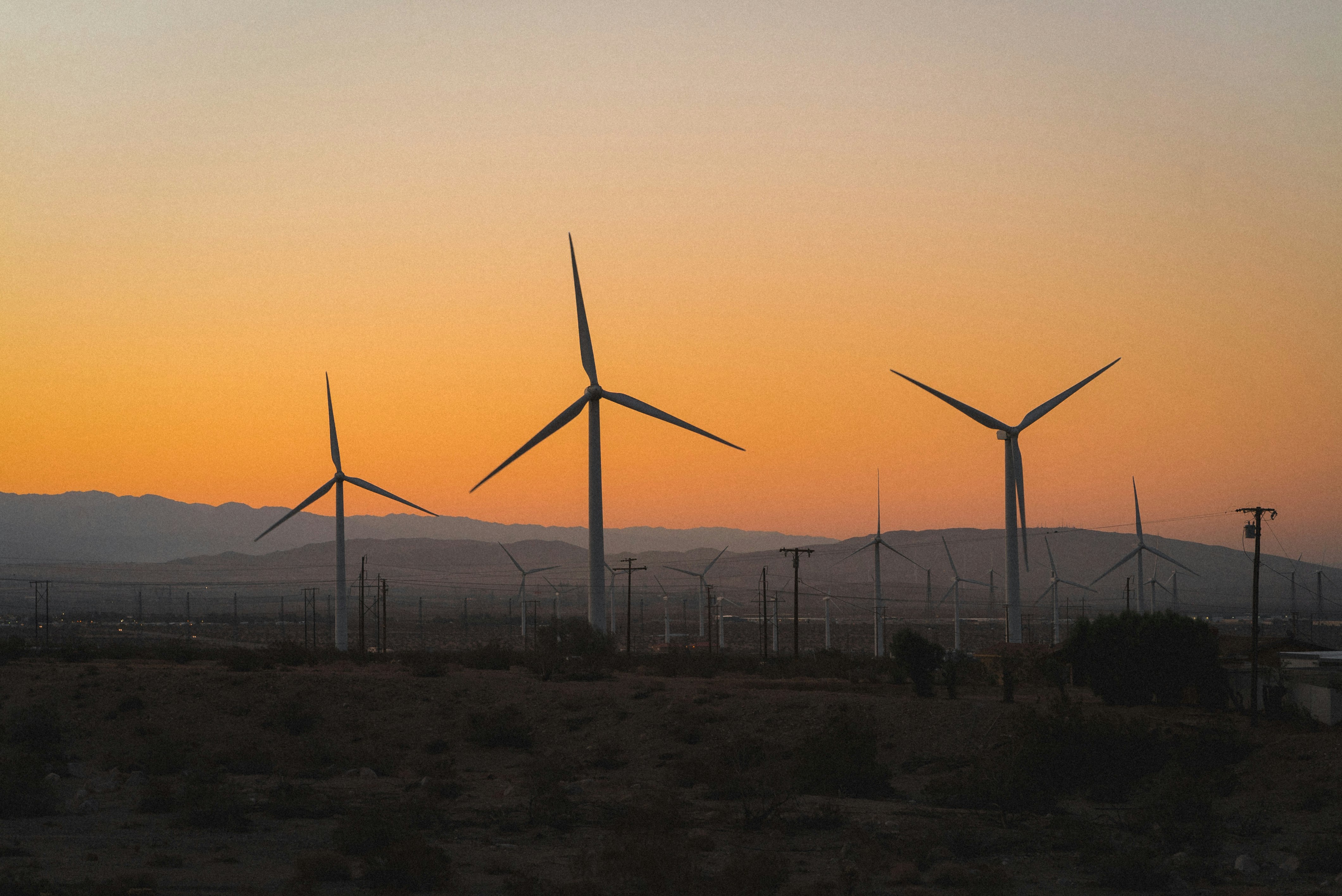 wind turbines on field during sunset